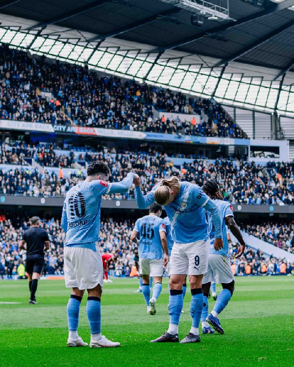Erling Haaland celebrates with Rayan Cherki