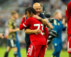 Liverpool boss Arne Slott hugs matchwinner Rio Ngumoha