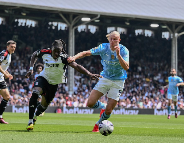 Erling Haaland holds off the challenge from Fulham's Calvin Bassey