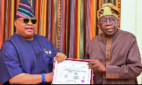 Osun State Governor, Ademola Adeleke, presenting his return certificate to President Bola Tinubu