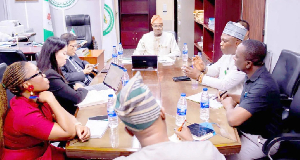 Adeniyi Adeyemi (m) presiding over a meeting in his office