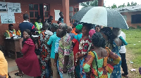 Voter waiting to cast their votes under the rain
